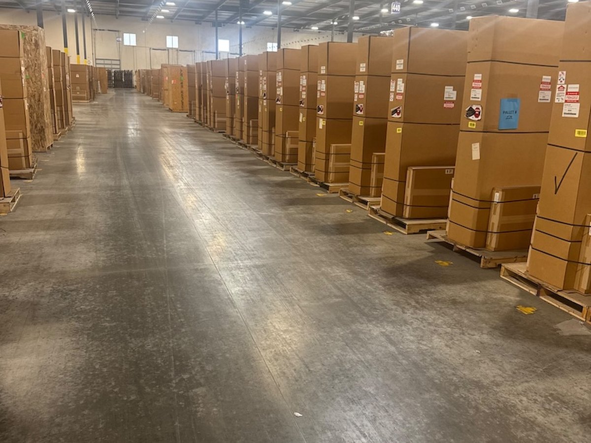 Rows of factory-crated BTC Power hardware in indoor storage