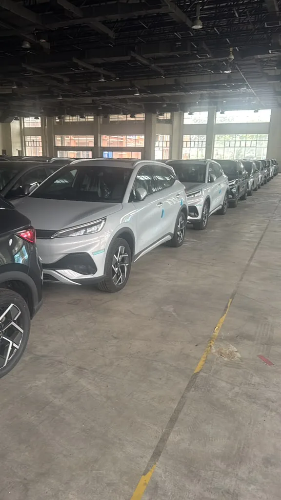 倉庫に駐車されたシルバーとダークカラーの BYD Atto 3 コンパクト電動SUVの列