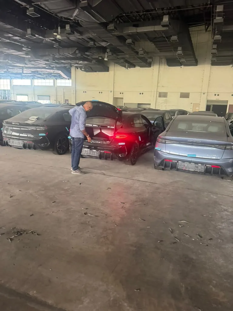 テールランプが点灯した BYD Seal のテールゲートを開ける検査員