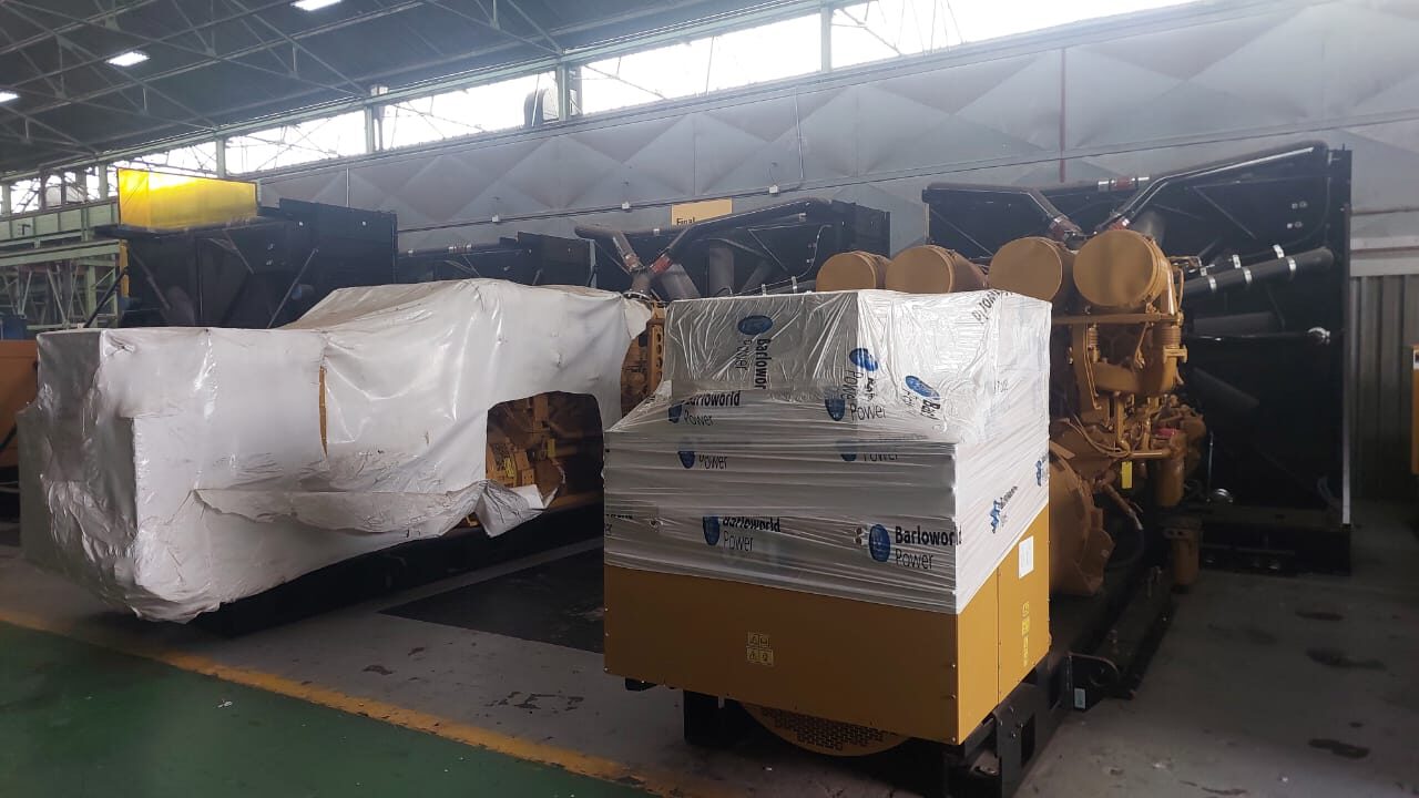 Two Caterpillar 3516E generator sets side by side in warehouse