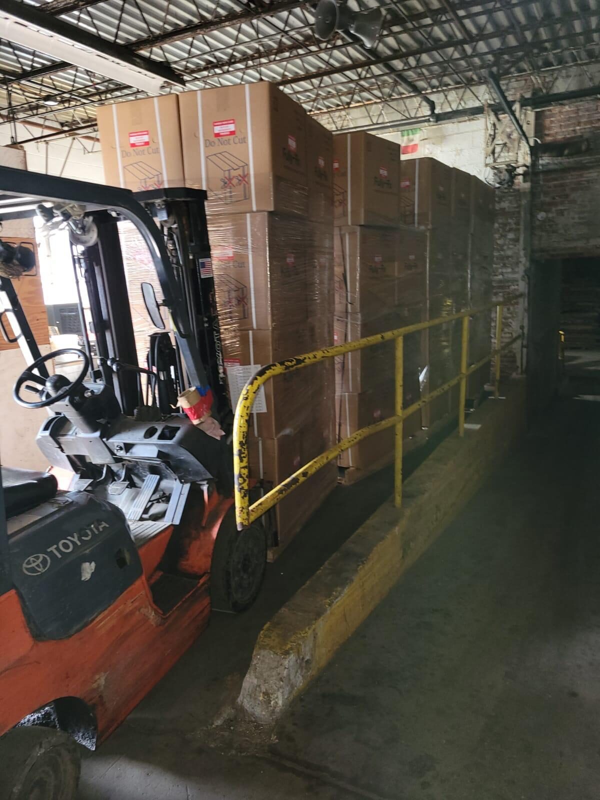 Forklift loading pallets of Yuyama pill counters onto truck